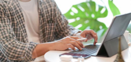 Person in black and white plaid dress shirt using laptop