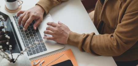 Person in brown long sleeve shirt using Macbook Pro.