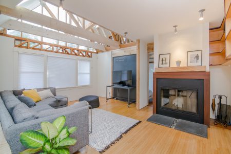 Rustic living room with TV, couch, fireplace, and wood floors as part of a virtual home tour.