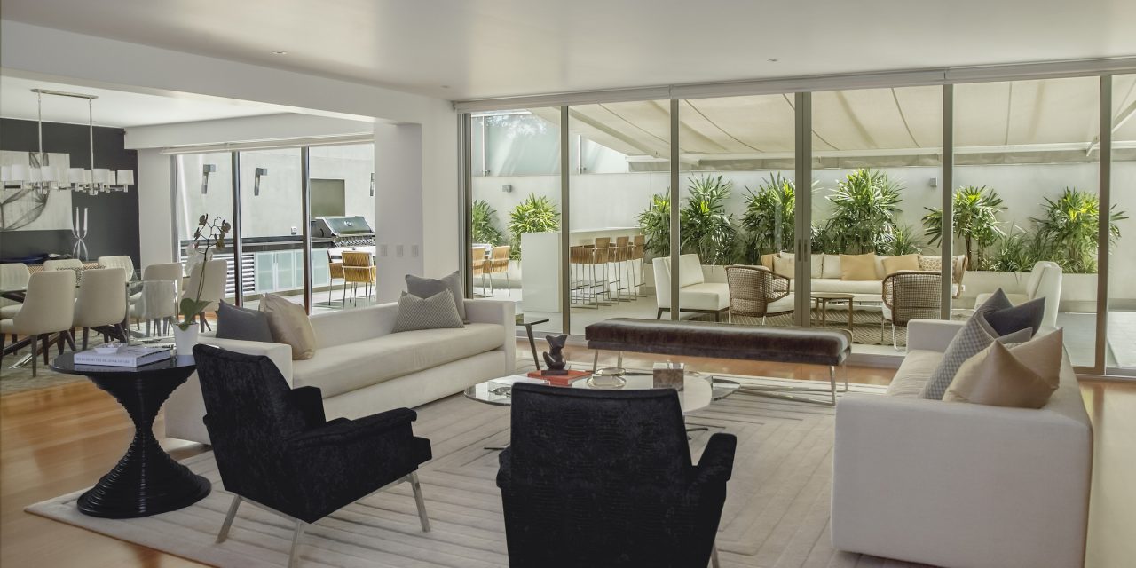 Living room and kitchen in a home with large windows and modern, sophisticated decor. as part of a virtual home tour.