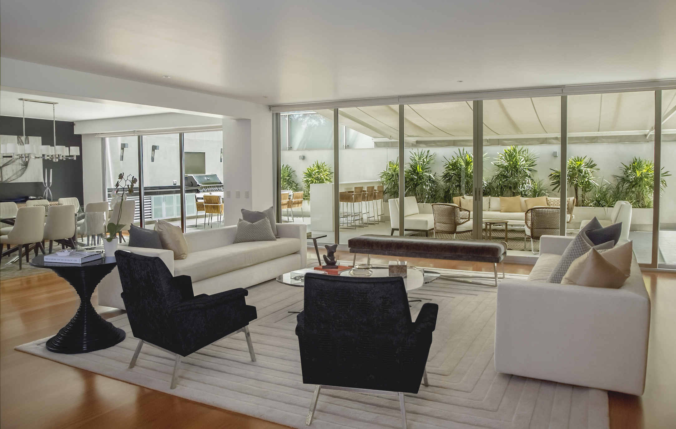 Living room and kitchen in a home with large windows and modern, sophisticated decor. as part of a virtual home tour.