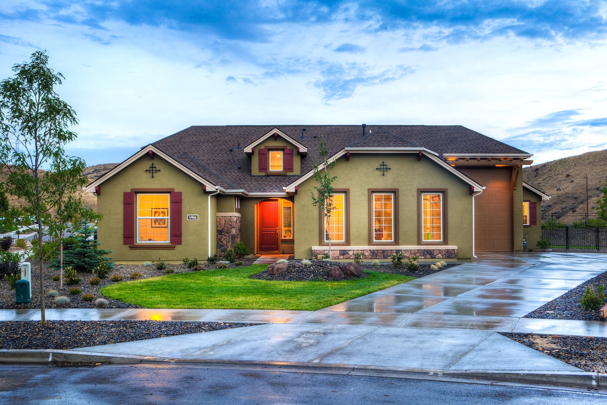 This is a picture of a house with five windows, one on the left of the front door, three on the right of the front door. There's one window above the front door as well. The lawn is relatively simple. Keep lawns fairly neutral, as buyers may want to personalize them.