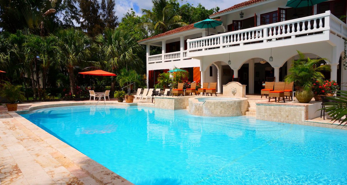 An image of a large blue pool in front of a house.