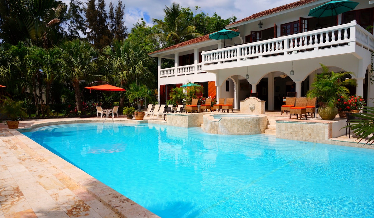 An image of a large blue pool in front of a house.